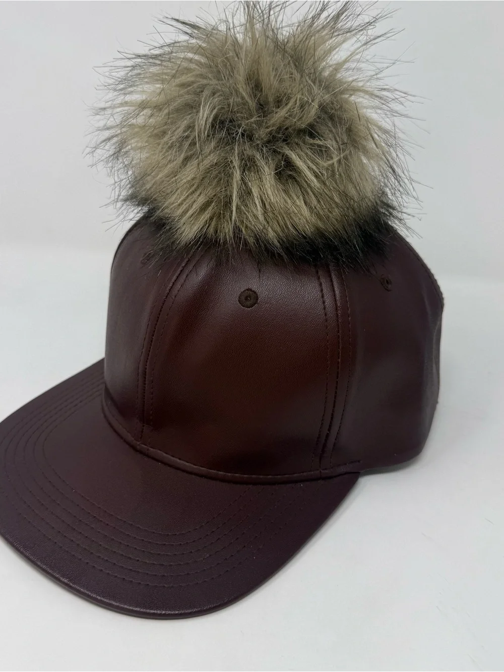 faux leather baseball cap by Premium Hatco features a faux fur pompom